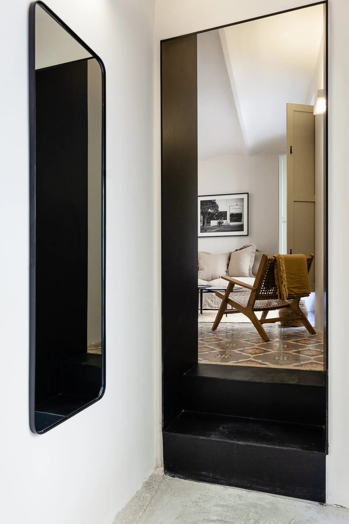 Living area with an armchair, artwork and patterned tile floor