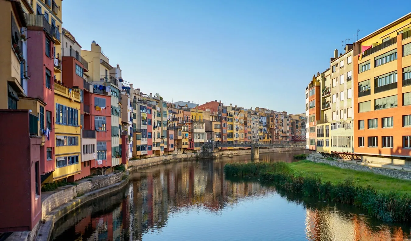 The painted houses along the Onyar river in Girona, with the cathedral behind