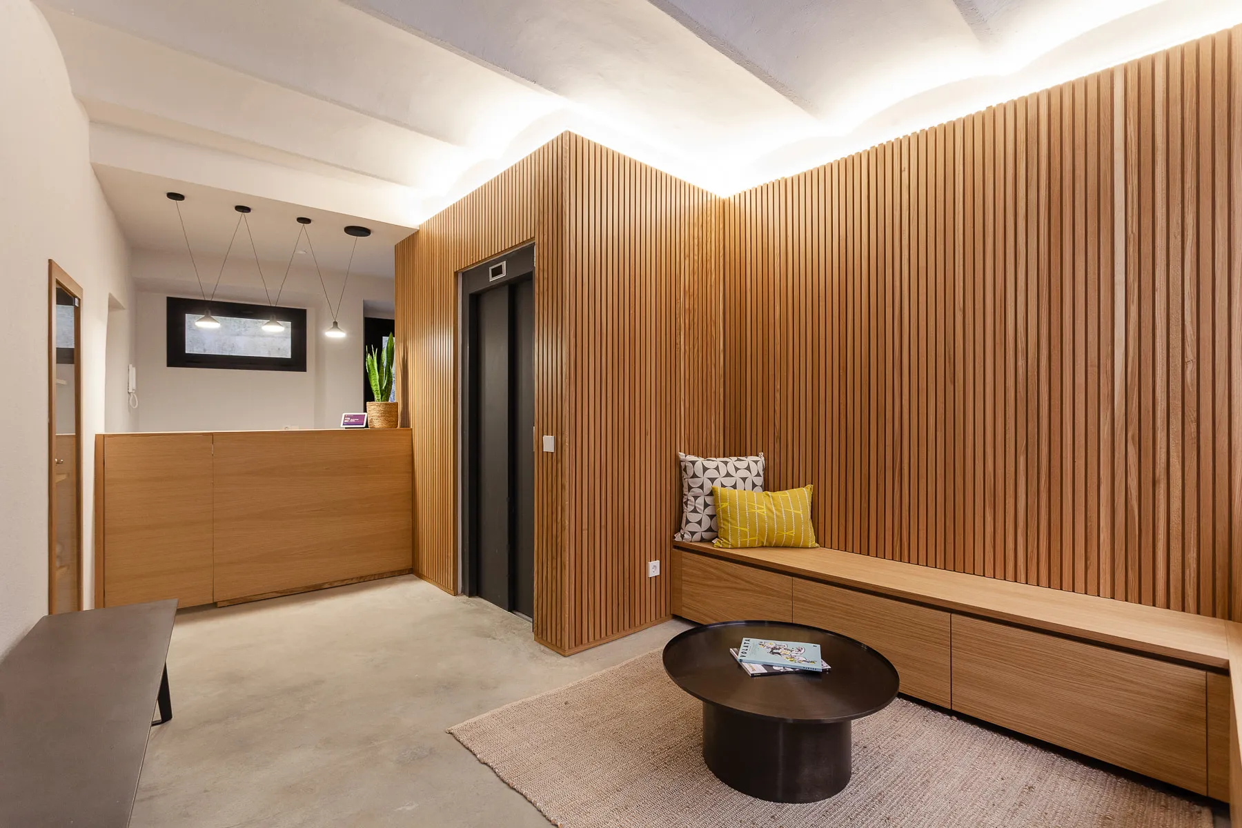 Ground-floor reception and lounge with timber slatted walls and bench seating